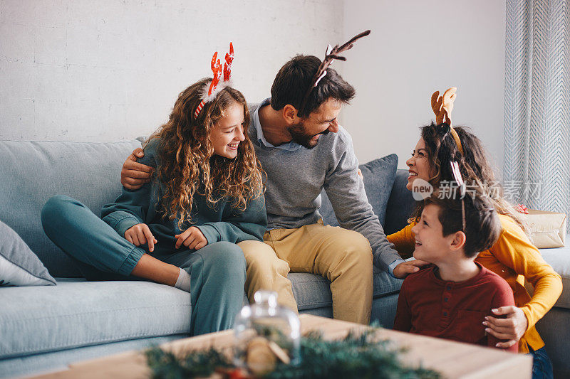 孩子和父母坐在客厅，分享爱和拥抱。新年的概念。