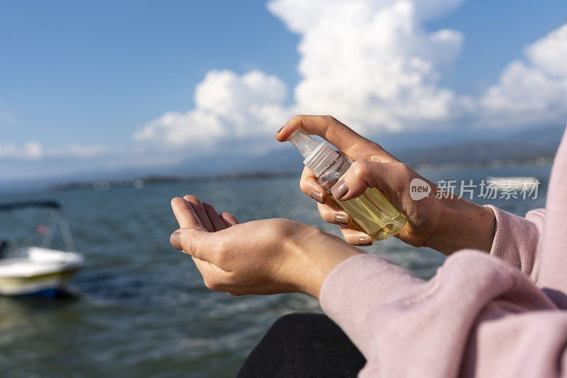 特写的一个白人妇女在街上消毒他的手从一个瓶子洗手液