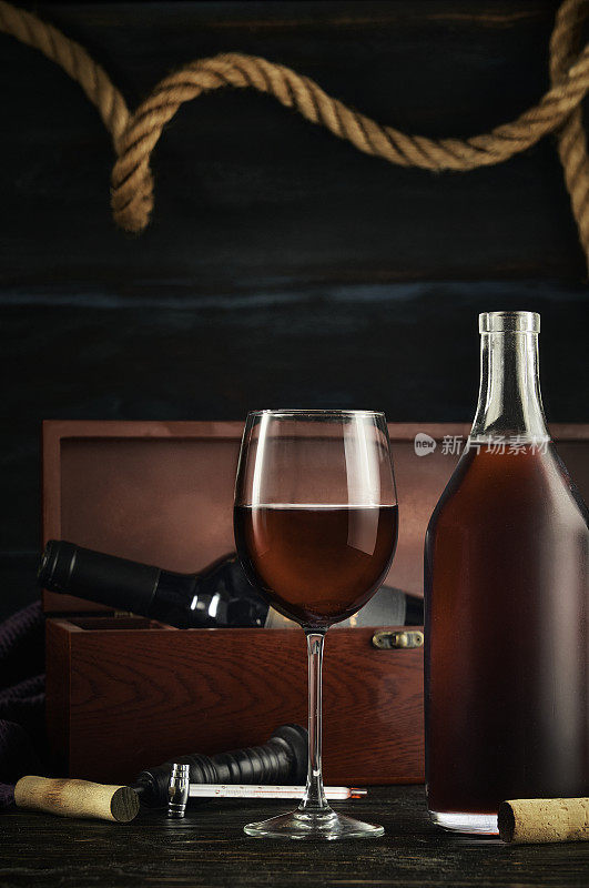 低调的红色酒瓶和杯子在一个质朴的航海环境酒吧