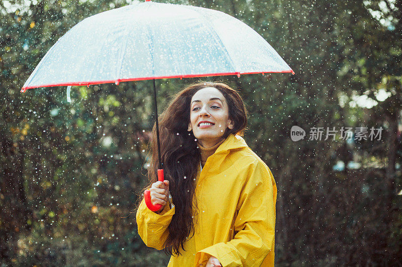 快乐的女人在雨中行走