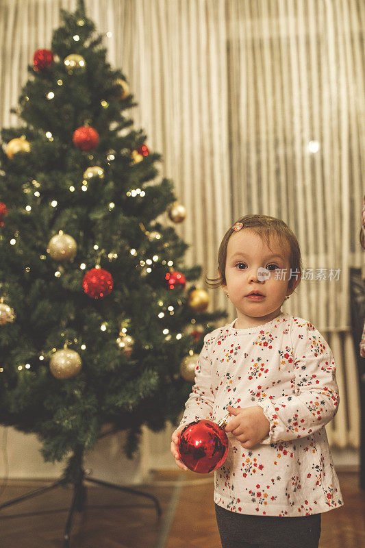 可爱的小女孩站在圣诞树前的肖像