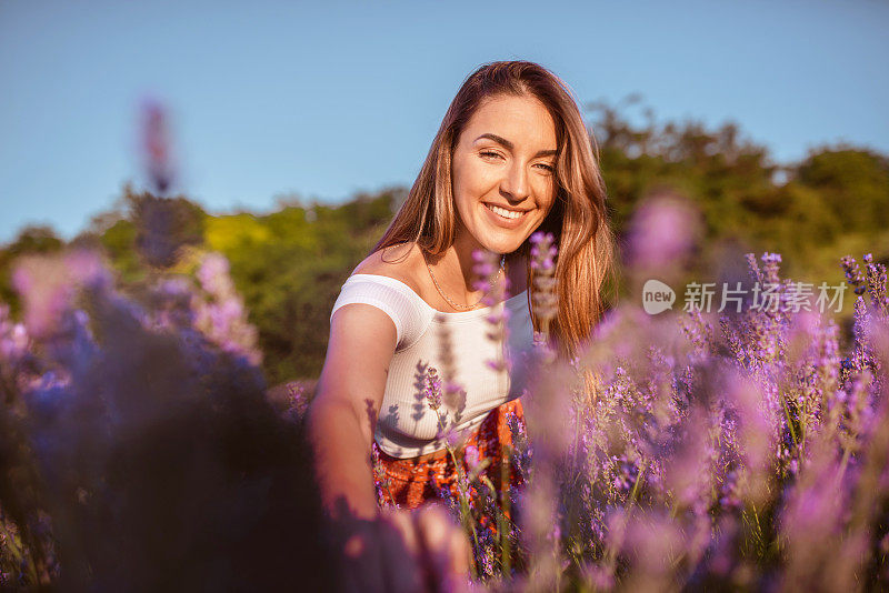 美丽的年轻女子在紫色的薰衣草地里