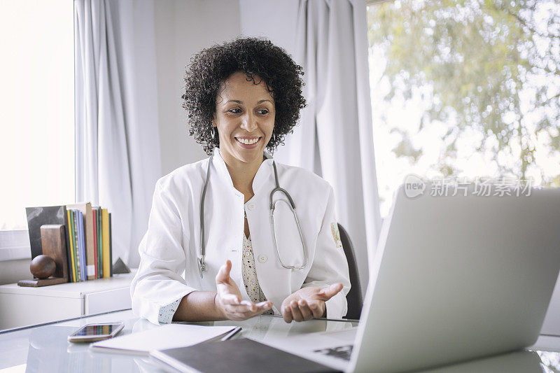 黑人女医生使用笔记本电脑进行远程医疗视频通话。