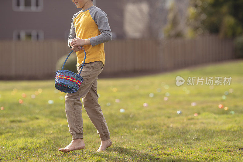 光着脚的男孩走在草地上复活节彩蛋小屋