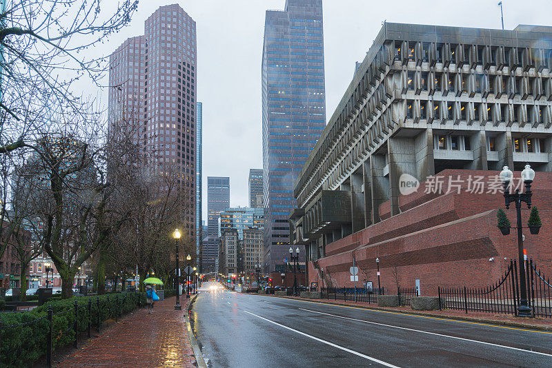 在美国马萨诸塞州波士顿市中心的雨天，人群、行人和交通车辆与高层建筑