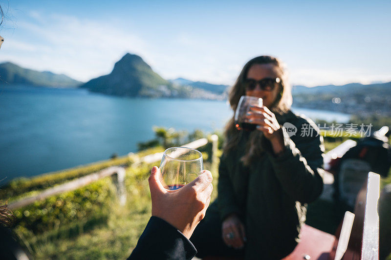 年轻的姑娘们在湖边欣赏美酒