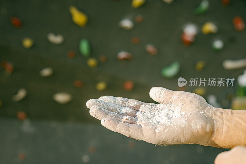 特写登山者手涂白色粉末，抱石墙