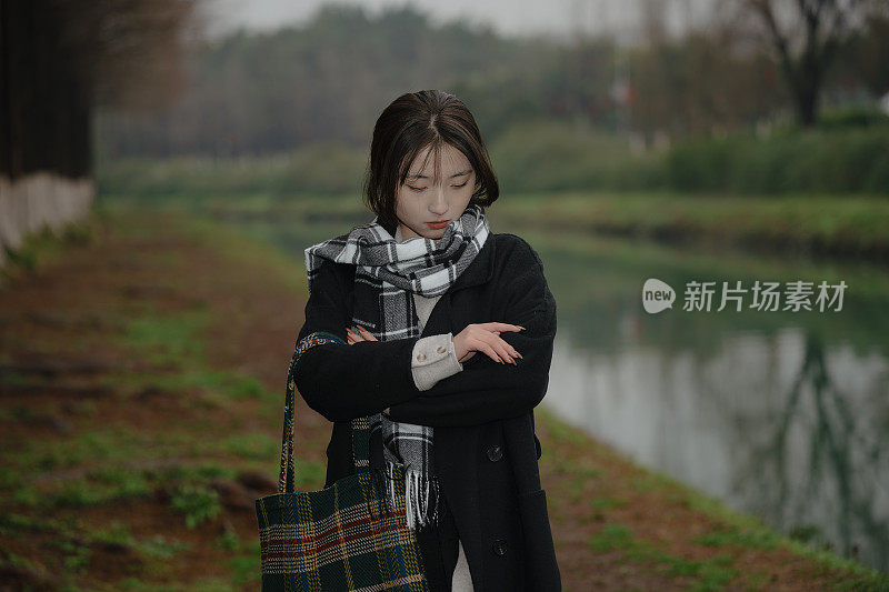 亚洲女孩走在河边的雨天