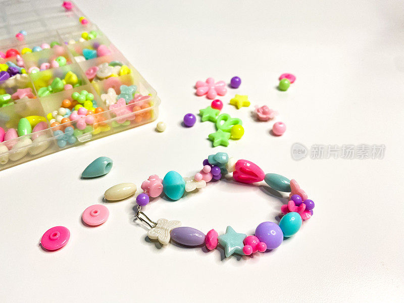 一盒彩色的珠子，一种用来制作塑料手镯或女孩饰品的工具。自己动手的概念