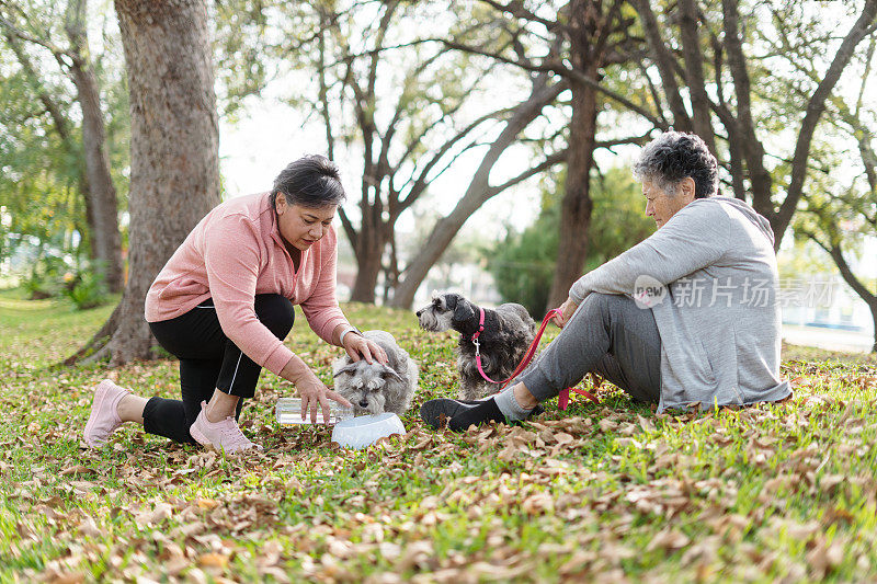 母女俩在公园里喂狗喝水