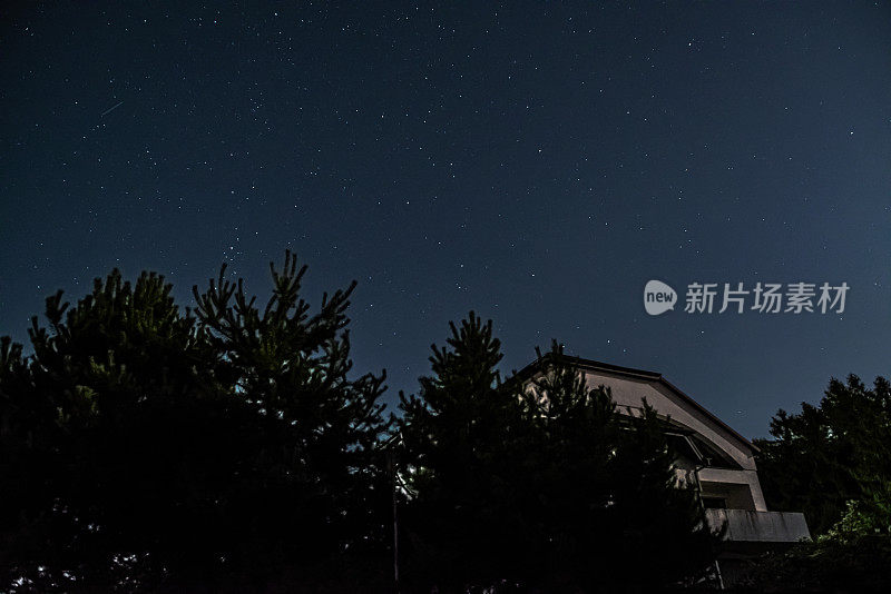 月光下的屋顶和上面的星空的照片。明星、屋顶、梦想。星空的大气摄影。在屋顶上散步，欣赏星星。软焦点
