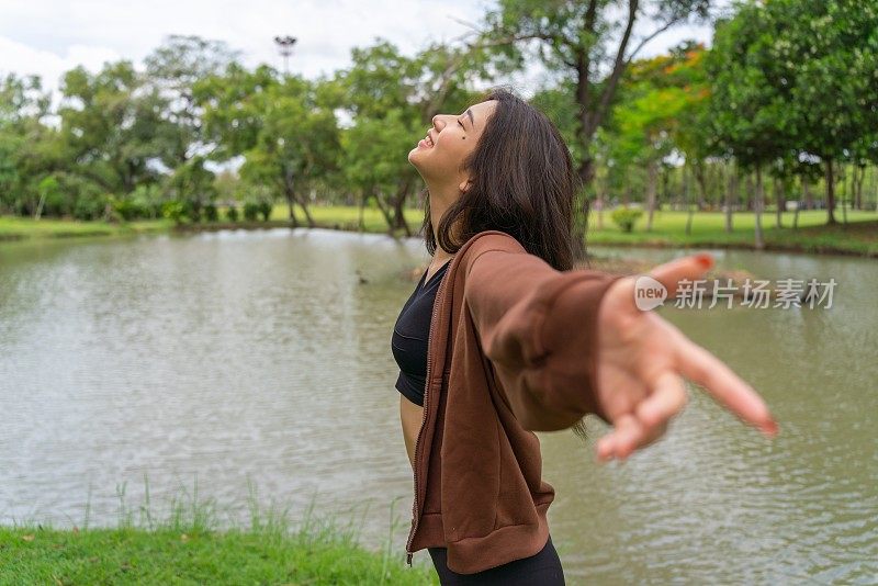 年轻的亚洲女性在公园里享受清风