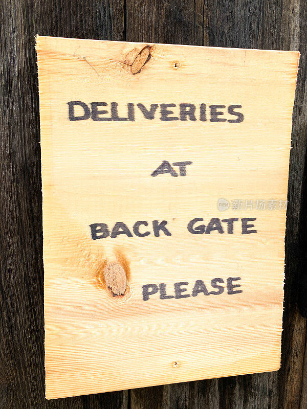 木牌上写着:请在后门送货