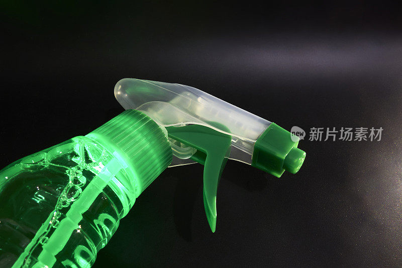 鱼叉瓶与绿色清洁剂在黑色背景