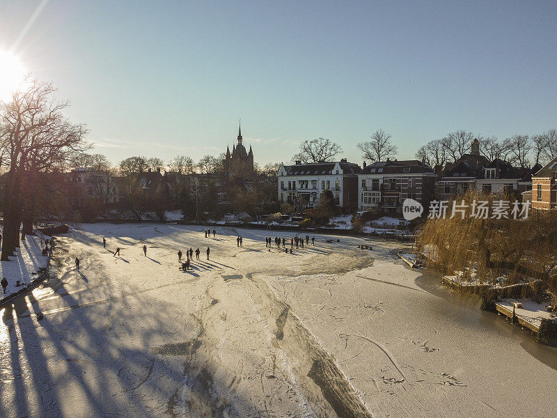 在一个美丽的冬日，人们在兹沃勒结冰的运河上滑冰