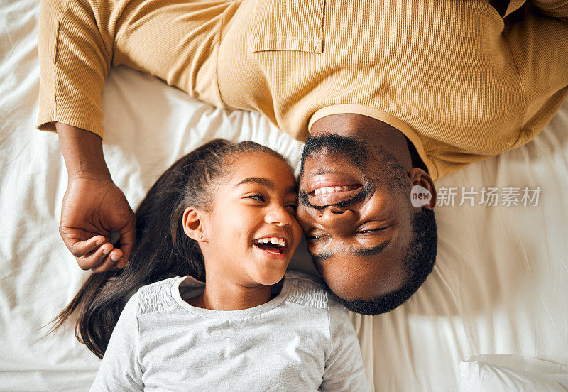 黑户人家，父女相爱地躺在床上，脸上带着微笑，回忆着趣事。上面的男人和孩子一起在家里的卧室里建立联系，支持和照顾与安全