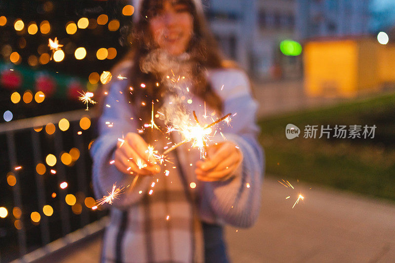 一个美丽的女人在户外拿着烟火的特写