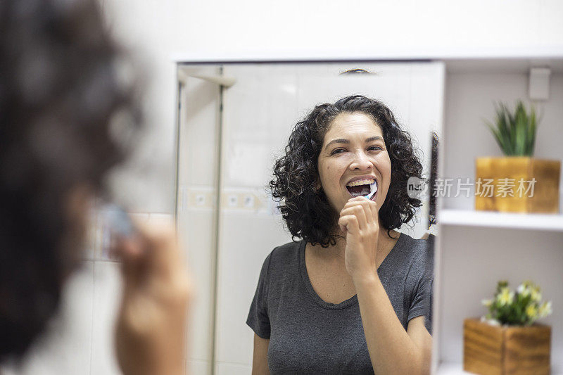 拉丁女人在浴室里愉快地刷牙