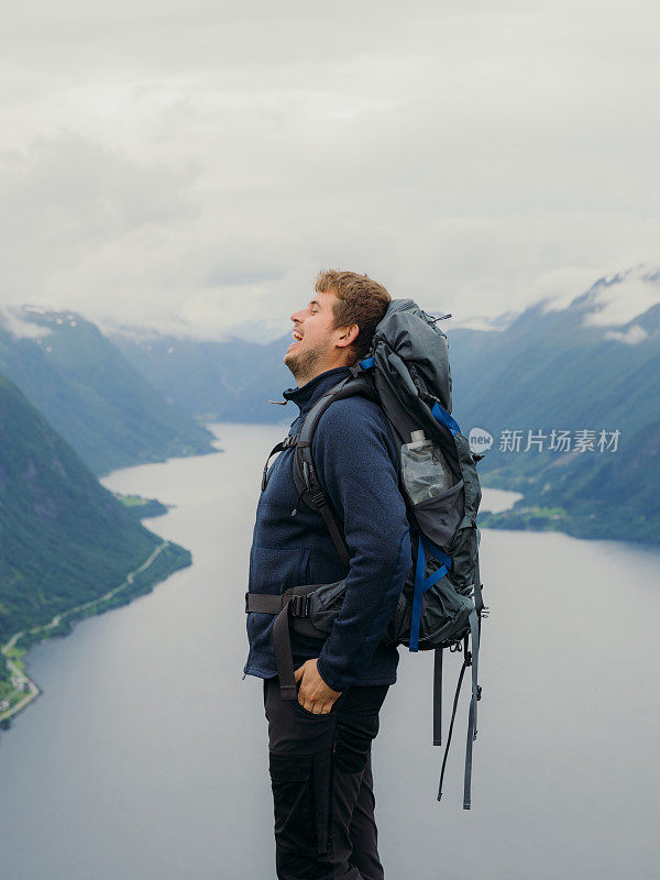 快乐的人背着背包在挪威的夏日山区徒步旅行