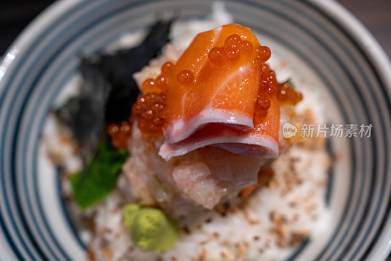 这是一碗著名的日本刺身顿饭的特写镜头，里面装满了鲑鱼和鲑鱼卵。