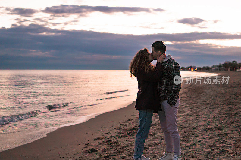 年轻的情侣在海滩上享受爱情