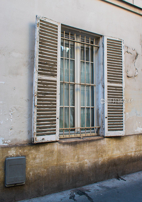 位于巴黎建筑物底层的带栏杆的窗户