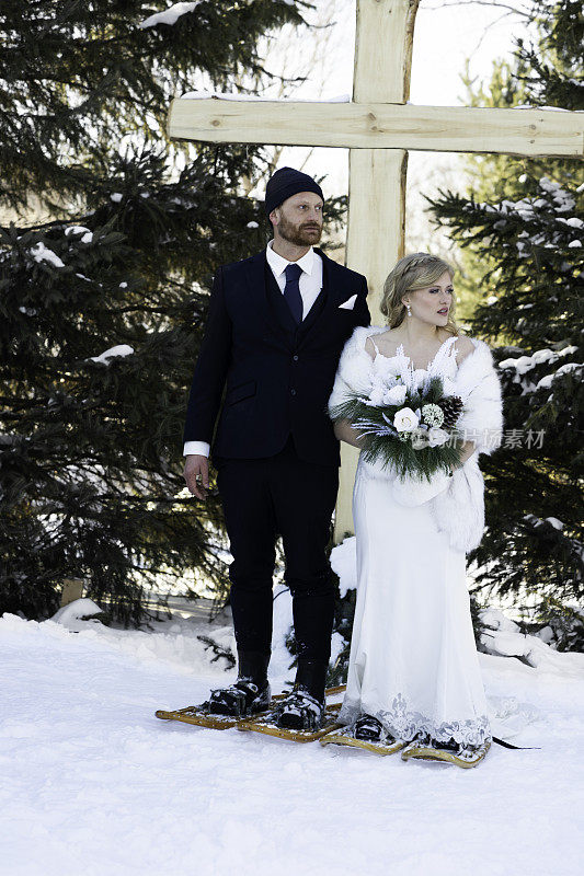 一对穿着雪鞋的新婚夫妇穿过马路