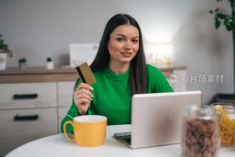 美女一边在厨房吃早餐一边网购