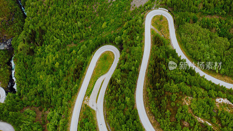 鸟瞰图汽车驾驶发夹路在风景秀丽的绿山山谷在挪威