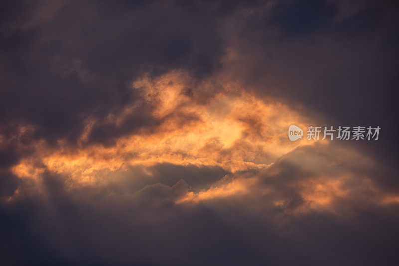 戏剧性的日落天空背景:阳光穿透黑色雷云