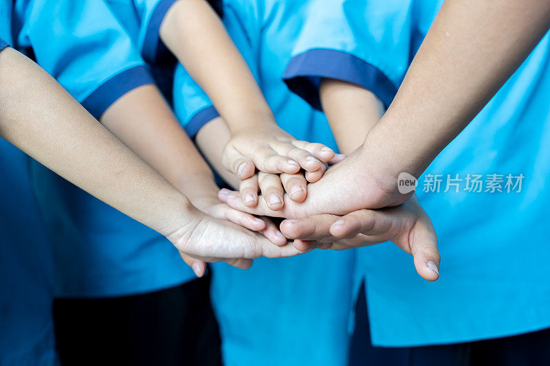 亚洲儿童手拉手，象征着他们的团结和支持。