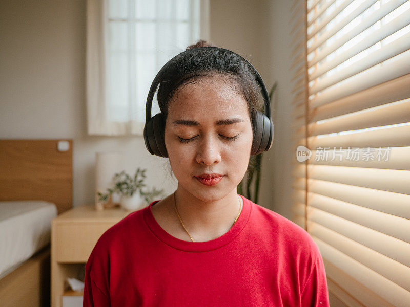 一名年轻女子在她的例行晨间冥想中收听一个冥想应用程序