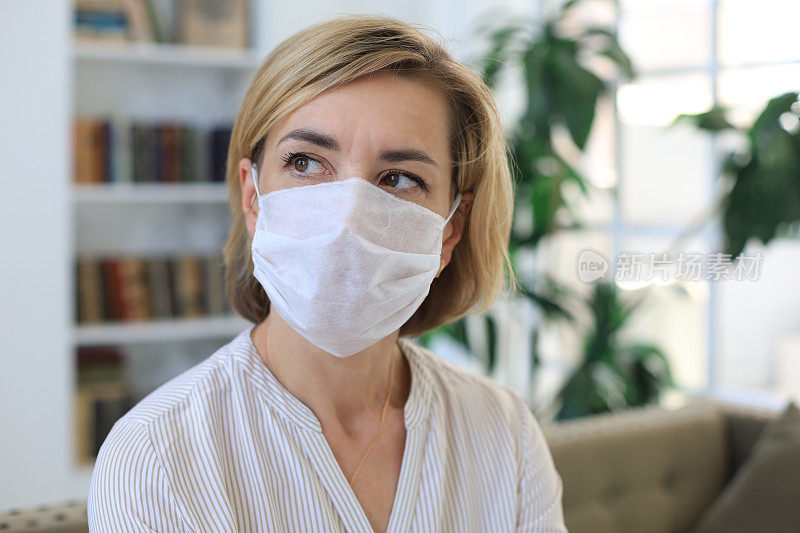 疫情期间居家佩戴医用口罩的中年妇女。