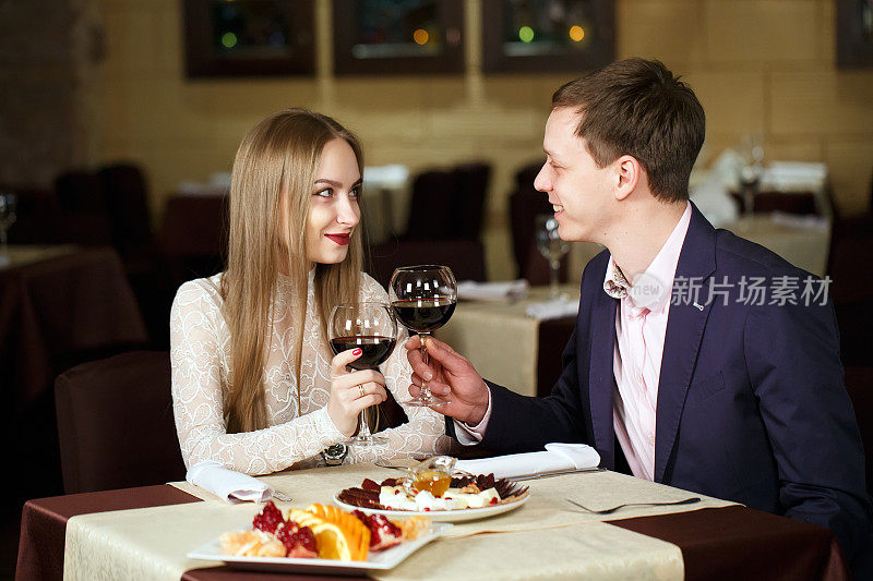 一对夫妇在一家豪华餐厅里敬酒杯。