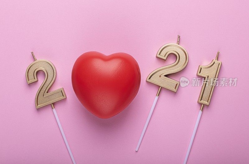 粉色心形2021年无数的金色生日蜡烛。