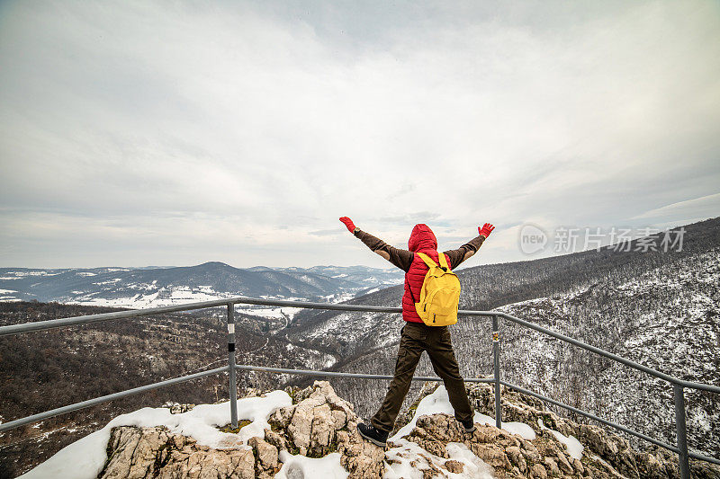 健康的生活方式。那位登山运动员从最高峰的瞭望台上眺望周围美丽的景色