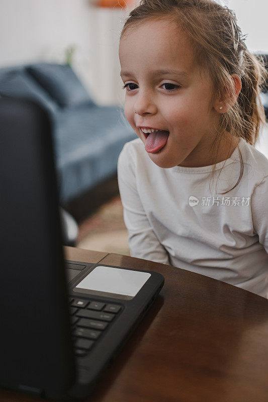 孩子坐在客厅里使用笔记本电脑
