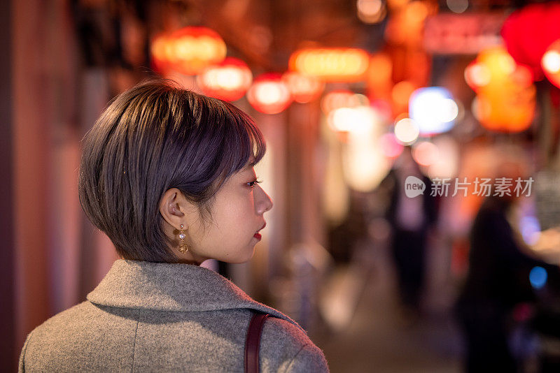 年轻女子参观日本“居酒屋”酒吧街