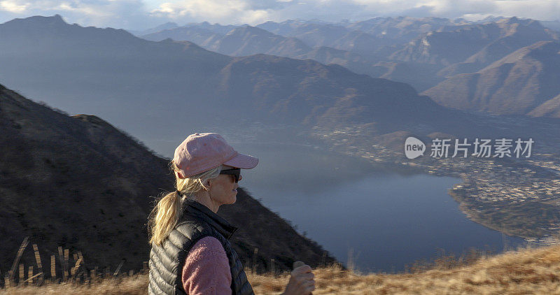 女性徒步旅行者在湖上和山上行走