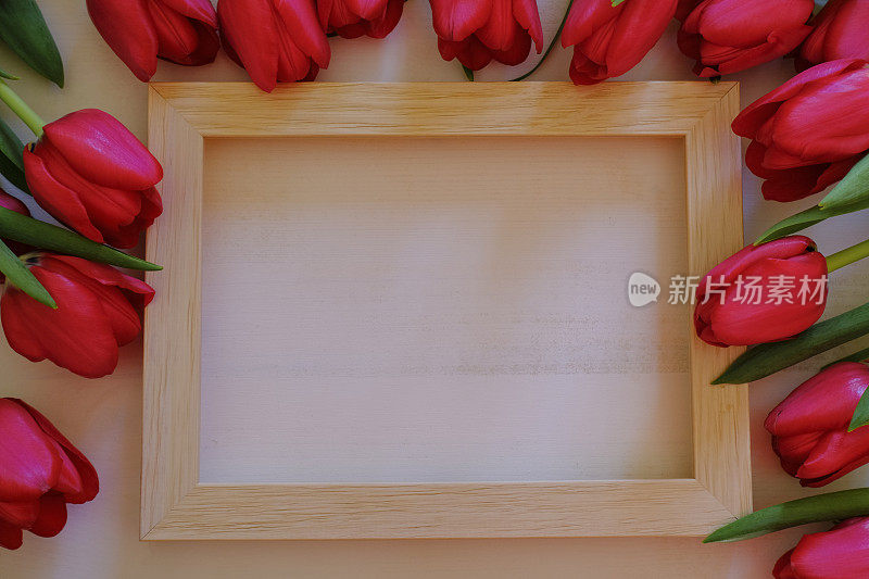框架红色郁金香横跨木制画框上的白色背景。前视图。副本的空间。美容、化妆、风格、时尚平铺