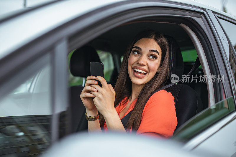 漂亮的年轻女子微笑和使用手机触摸车内屏幕旅行。现代概念的搜索和联系朋友时，你离开。智能手机的日常使用