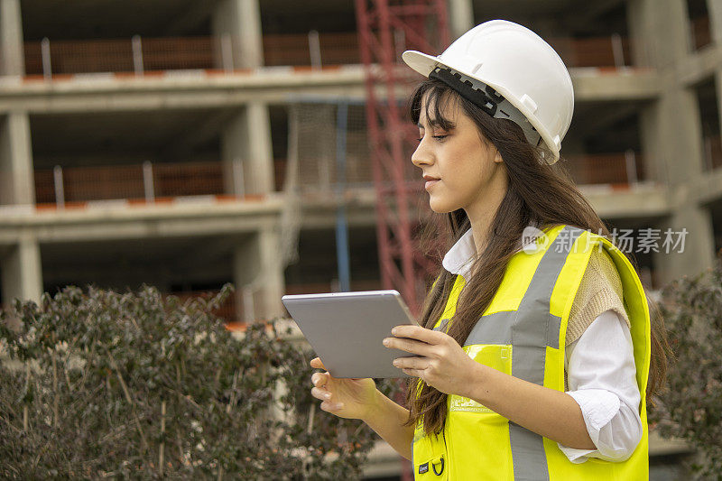 女建筑师在建筑工地与数字平板电脑