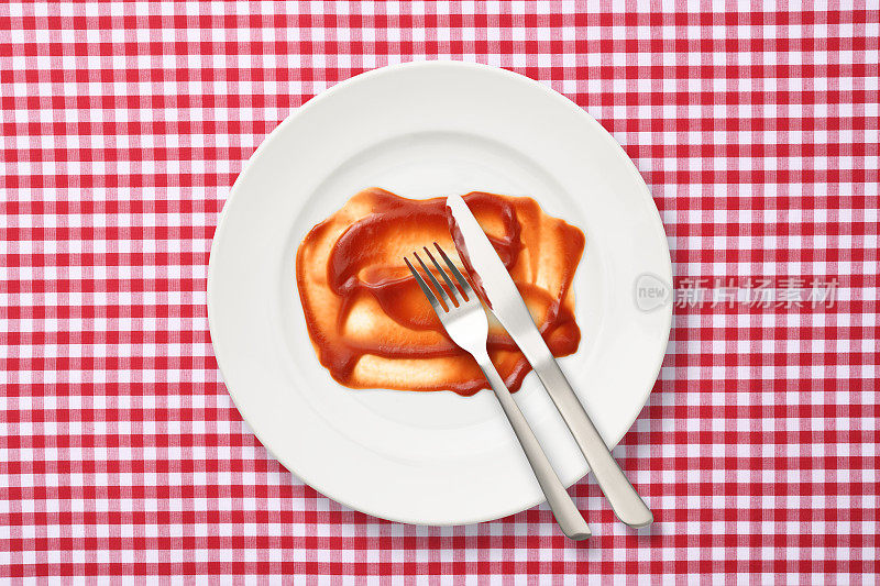 餐后白色盘子和蕃茄酱刀叉，方格桌布上