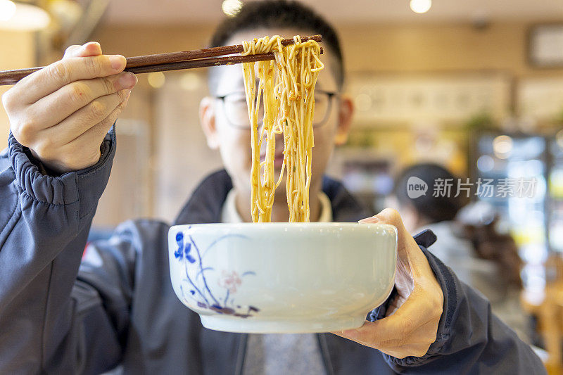 亚洲男子吃蟹黄虾面