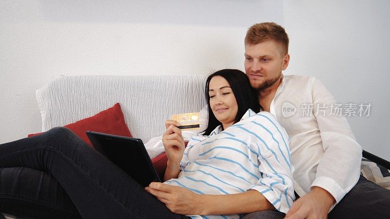 一对夫妻躺在沙发上，在网上购物