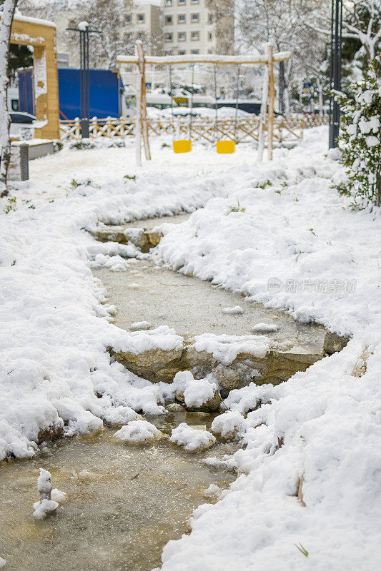 美丽的冬季公园，结冰的水覆盖着雪