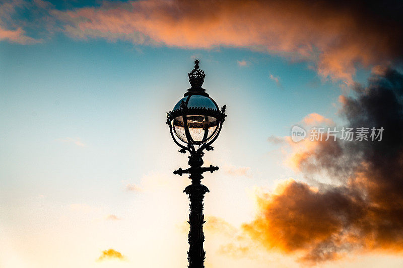 古老的老式灯柱上的夕阳天空的背景