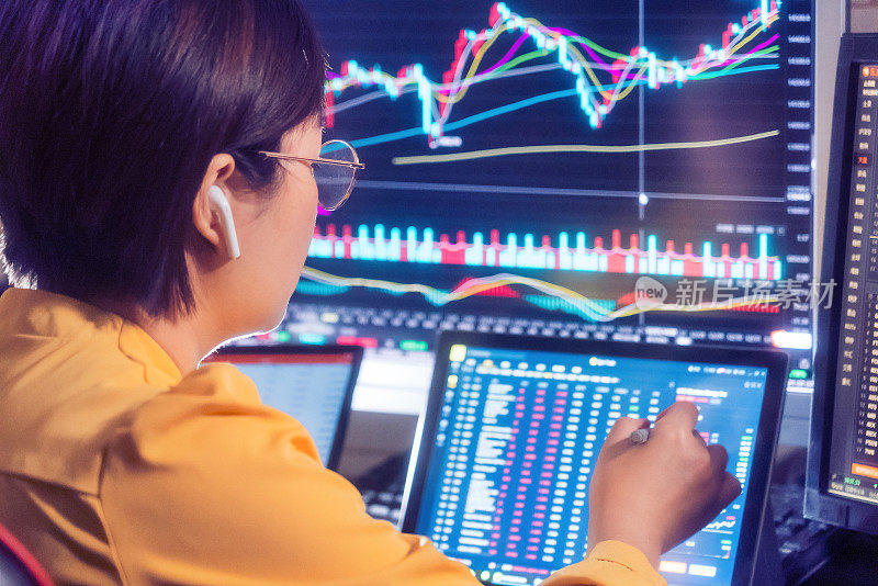 在电脑显示器上看股票市场的女人