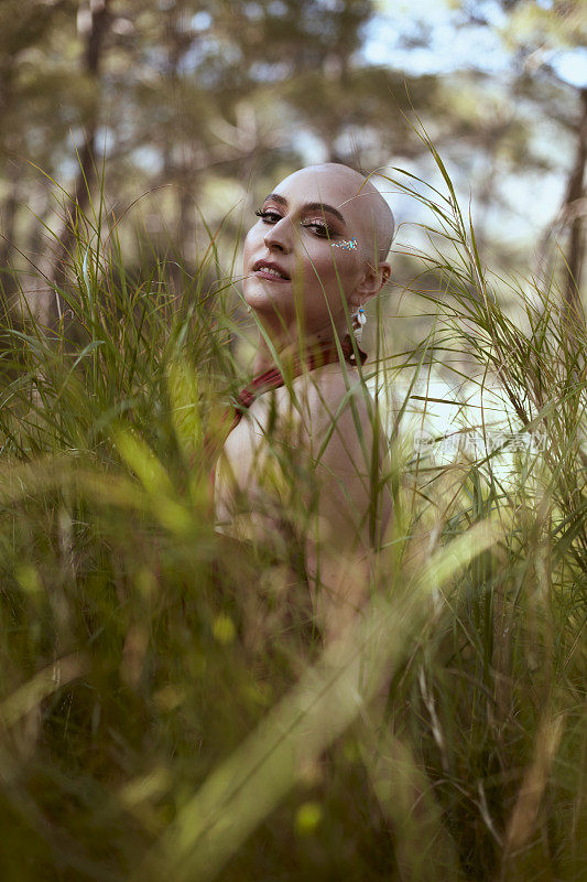 微笑的秃头美女在芦苇丛中战胜了癌症。