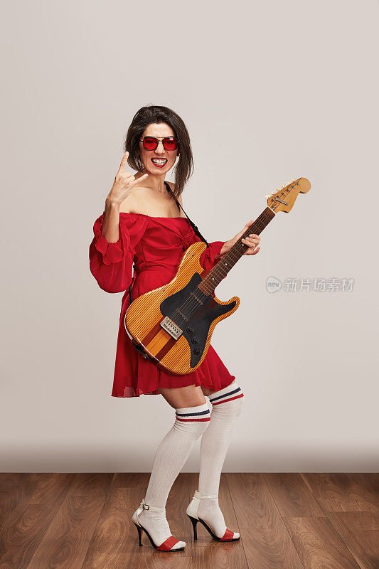 时髦的女摇滚歌手享受着白底电吉他的音乐